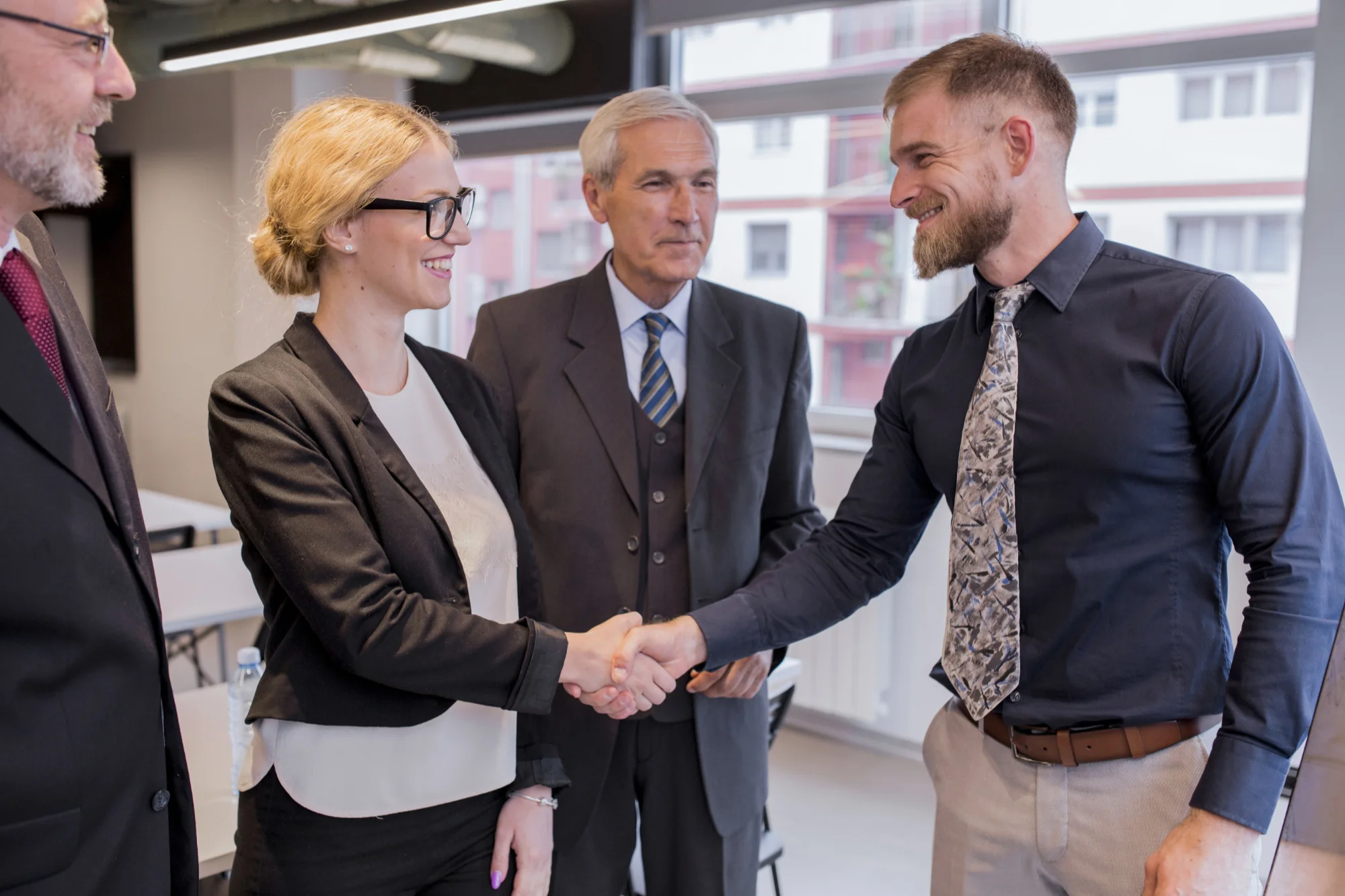 smiling-businesswoman-shaking-hand-with-businessman-office